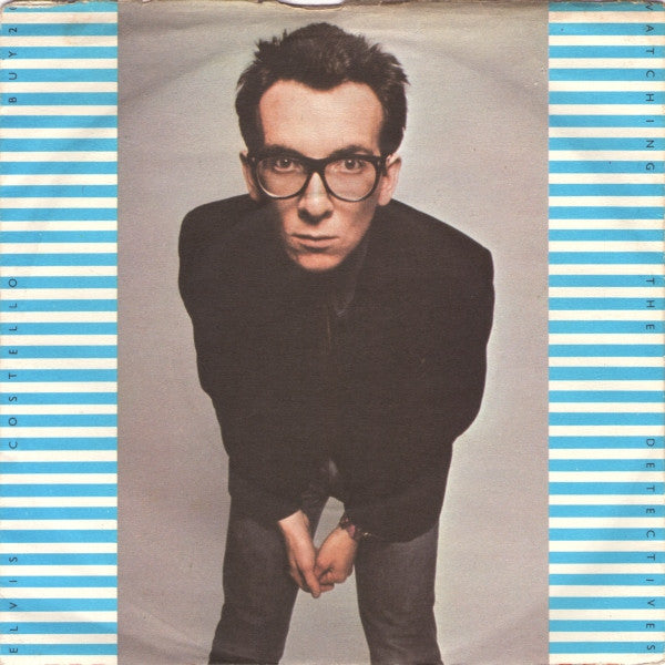 Elvis Costello - Watching The Detectives Vinyl Singles Vinyl Very Good (VG) <br> Hoes Good Plus (G+)